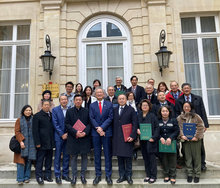 駐法國代表吳志中(左5)代表僑委會委員長童振源頒發新、續聘共計18位僑務榮譽職人員聘書。(圖/駐法國代表處提供)