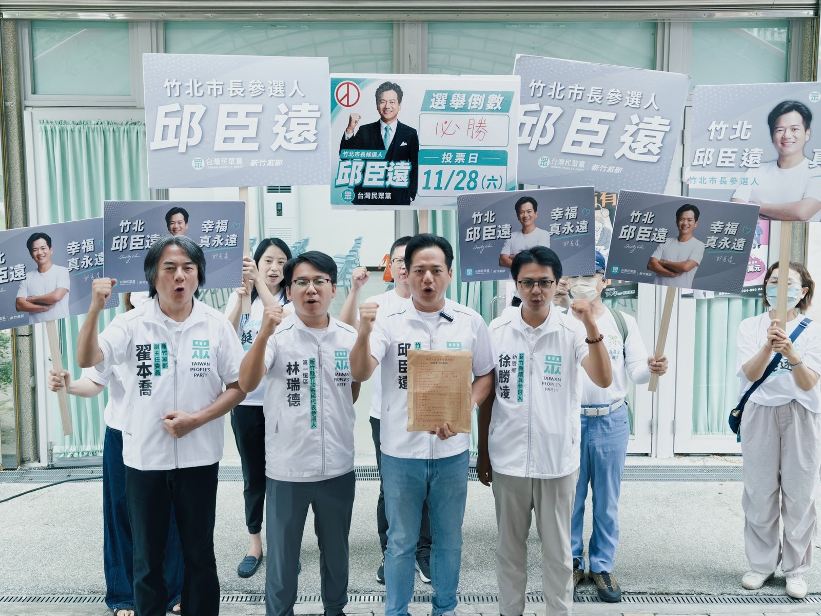 竹北市長候選人邱臣遠(右二)完成參選登記後,與競選團隊及支持者一同高喊口號。(邱臣遠競選辦公室提供)