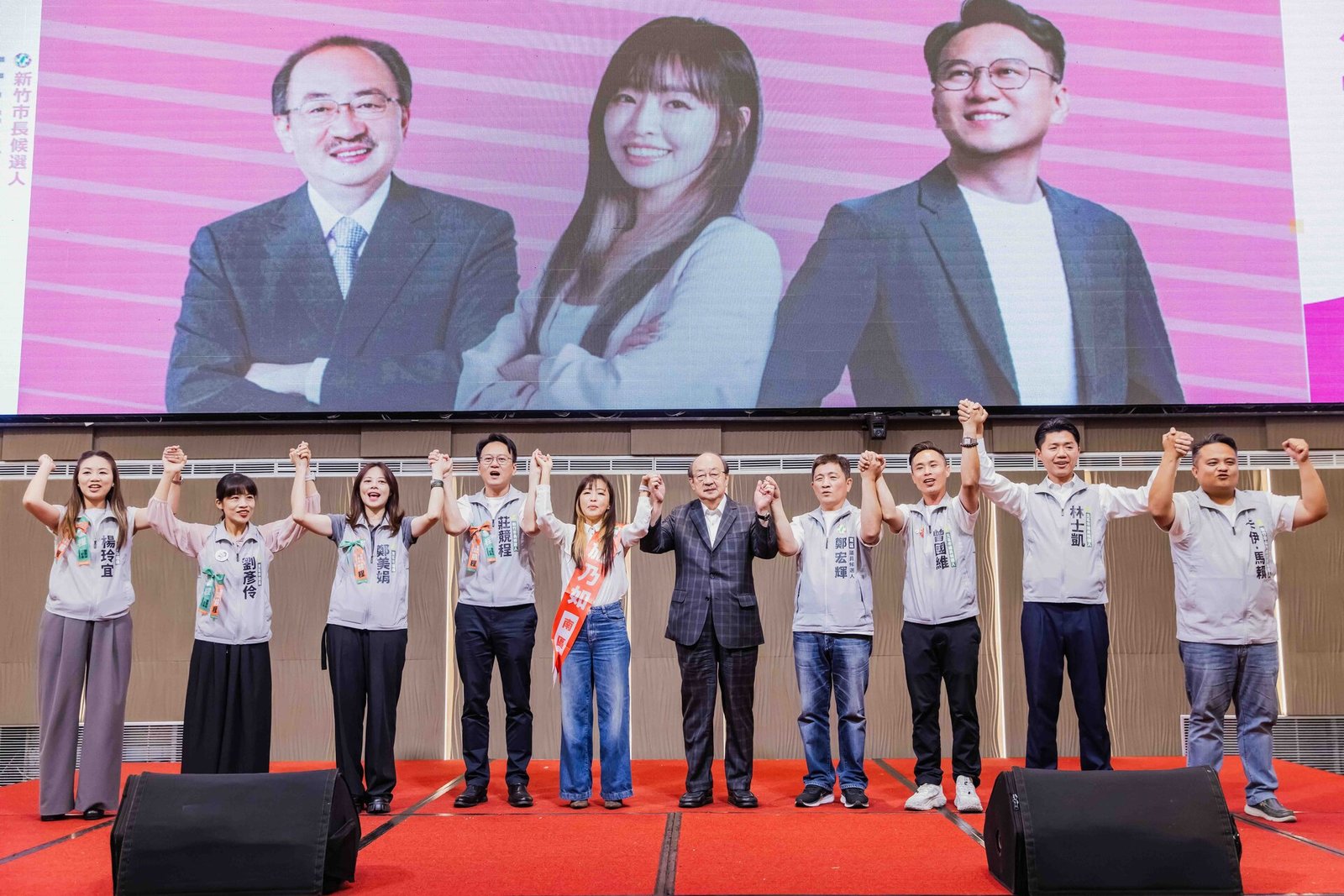 莊競程出席施乃如競選總部成立大會,新竹隊成員在台上牽手高舉,展現團結氣勢(莊競程競選辦公室提供)