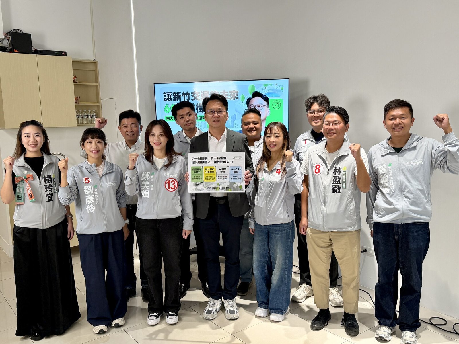 莊競程(中)手持交通政策文宣,與新竹市議員候選人合影(新唐人亞太電視)