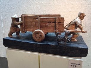嘉義木材城市早期街頭常見的人力拖板車運送木材，深具地方特色。