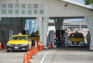 桃園機場COVID-19疫情擴大，台北市政府要求防疫計程車司機8日至9日須全數進行PCR檢測。許多司機及民眾9日上午前往大佳河濱公園車來速篩檢站採檢。（圖／中央社）