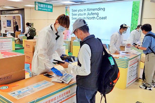 10月13日起入境人員免居隔改為「0+7」，無症狀旅客入境後可搭大眾運輸工具，自主防疫期間快篩陰性者可於餐廳內獨自或與特定對象共餐。 圖為桃機入境時由國際港埠人員向旅客發放家用抗原快篩試劑。（圖／中央社）