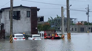受颱風尼莎及共伴效應影響，宜蘭16日降下滂沱大雨，宜蘭市清華二路附近淹水，道路受阻無法通行，8名旅客受困在民宿，消防局出動橡皮艇救援，協助旅客撤離。（圖／讀者提供）