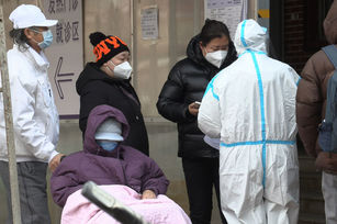  中共放寬防疫管制而疫情大爆發，據微博廣傳的北京某私立醫院內部會議錄音，高層說放寬後的當前首波嚴峻疫情只是開端，至少還得經歷4至5波。圖為14日北京人們在發熱門診外排隊照，。（圖／GettyImages）