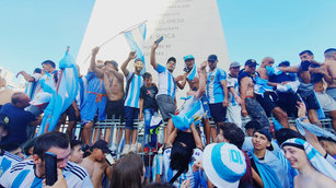 18日卡達世界盃冠軍戰阿根廷擊敗法國後，阿根廷首都布宜諾斯艾利斯景點方尖碑湧入超過百萬民眾，齊聚歡慶，民眾爬上方尖碑的圍牆，慶祝梅西為大家帶回36年來的第3座冠軍獎盃。（圖／中央社）