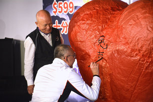 新北市副市長謝政達（圖右）11日出席2023新北市平溪天燈節記者會，現場揮毫在心型天燈上寫下新年吉祥話。左為天燈師傅胡民樹。（圖／中央社）