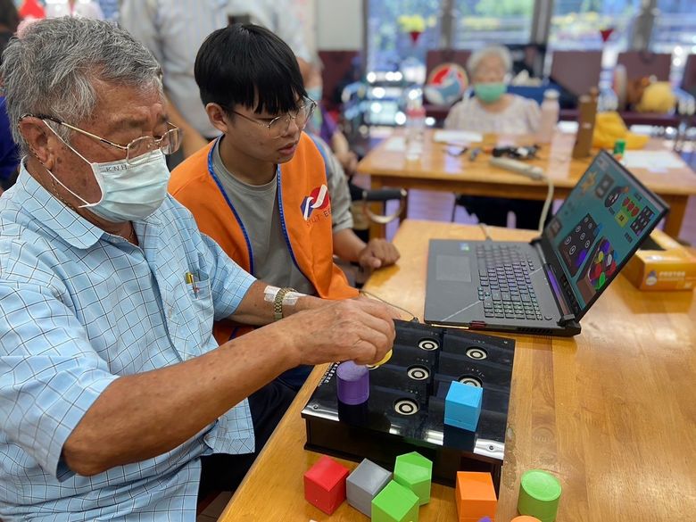 南台科大學生指導日照中心長輩進行「積木記憶遊戲」(朴子醫院提供)