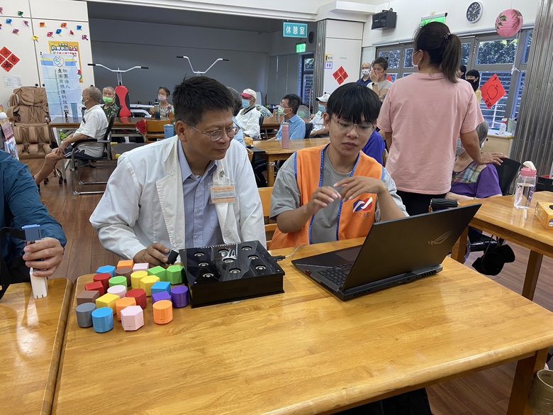 南台科大學生跟朴子醫院賴仲亮院長說明「積木記憶遊戲」(朴子醫院提供)