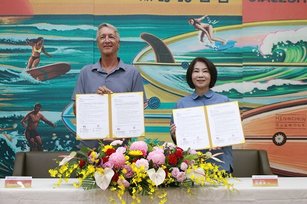 屏東縣長周春米（右）與亞洲衝浪聯盟（ASC）賽事經理提摩西海恩（左）簽訂合作備忘錄MOU，合力推動海洋運動。（屏東縣政府提供）