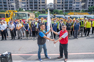 由高市府副秘書長王啓川授旗給高雄市政府救災團隊。(圖／高市府)