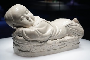 國寶文物〈定窯白瓷嬰兒枕〉造型可愛且具冰涼感，是古人夏季消暑的理想寢具。（故宮南院提供）